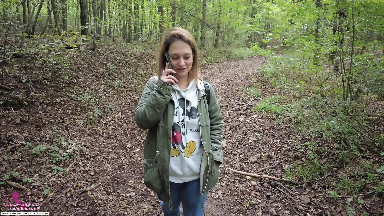 Kinky brunette strolls through woods talking phone gets horny