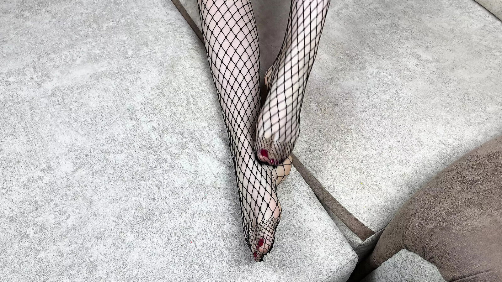Mistress black fishnet stockings caresses legs with pedicure