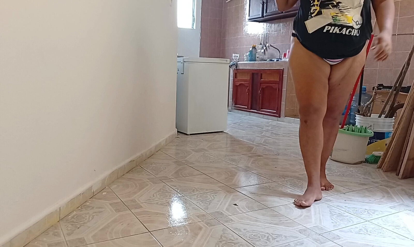 left cell phone recording while lady cleaning apartment