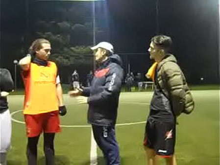 sweaty football player grabbing while spitting grass