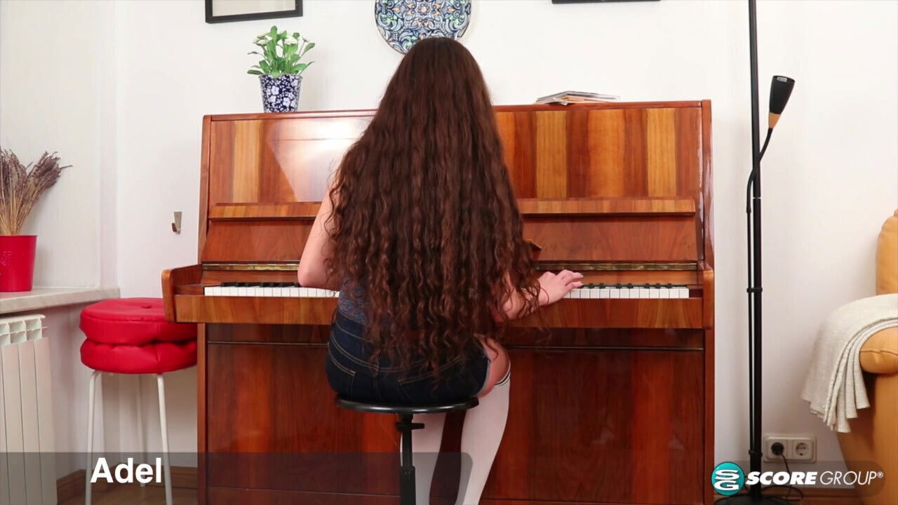 Adel, cutie with long, flowing brunette hair, plays