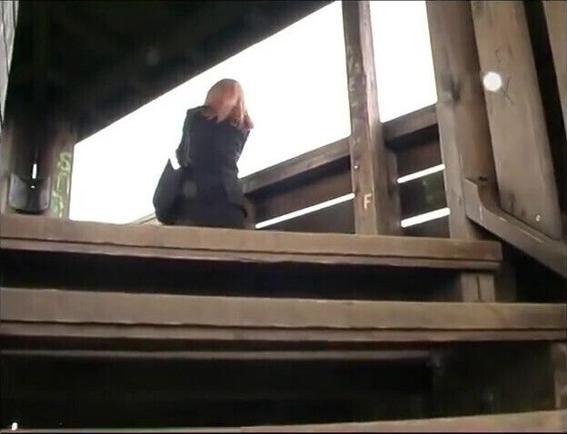 Horny girl sticks a long dildo into her shaved pussy outdoors