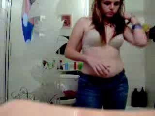 Curvy young brunette filming herself strip dancing