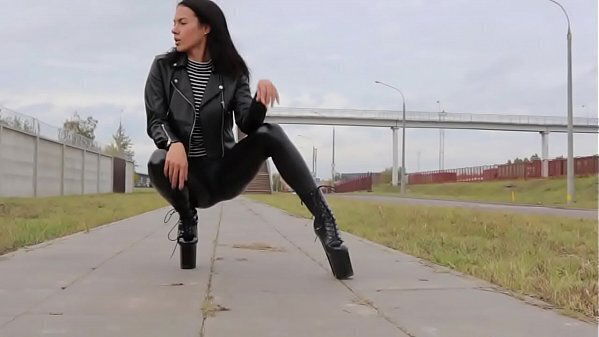Brunette wearing tight leather leggings, heels leather biker jacket