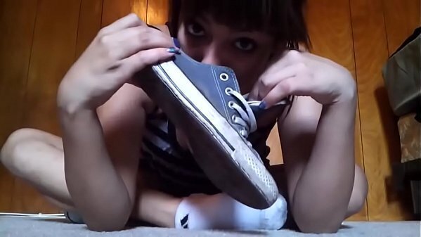 Chica hermosa quita converse calcetines para mostrar ricos pies sudados.