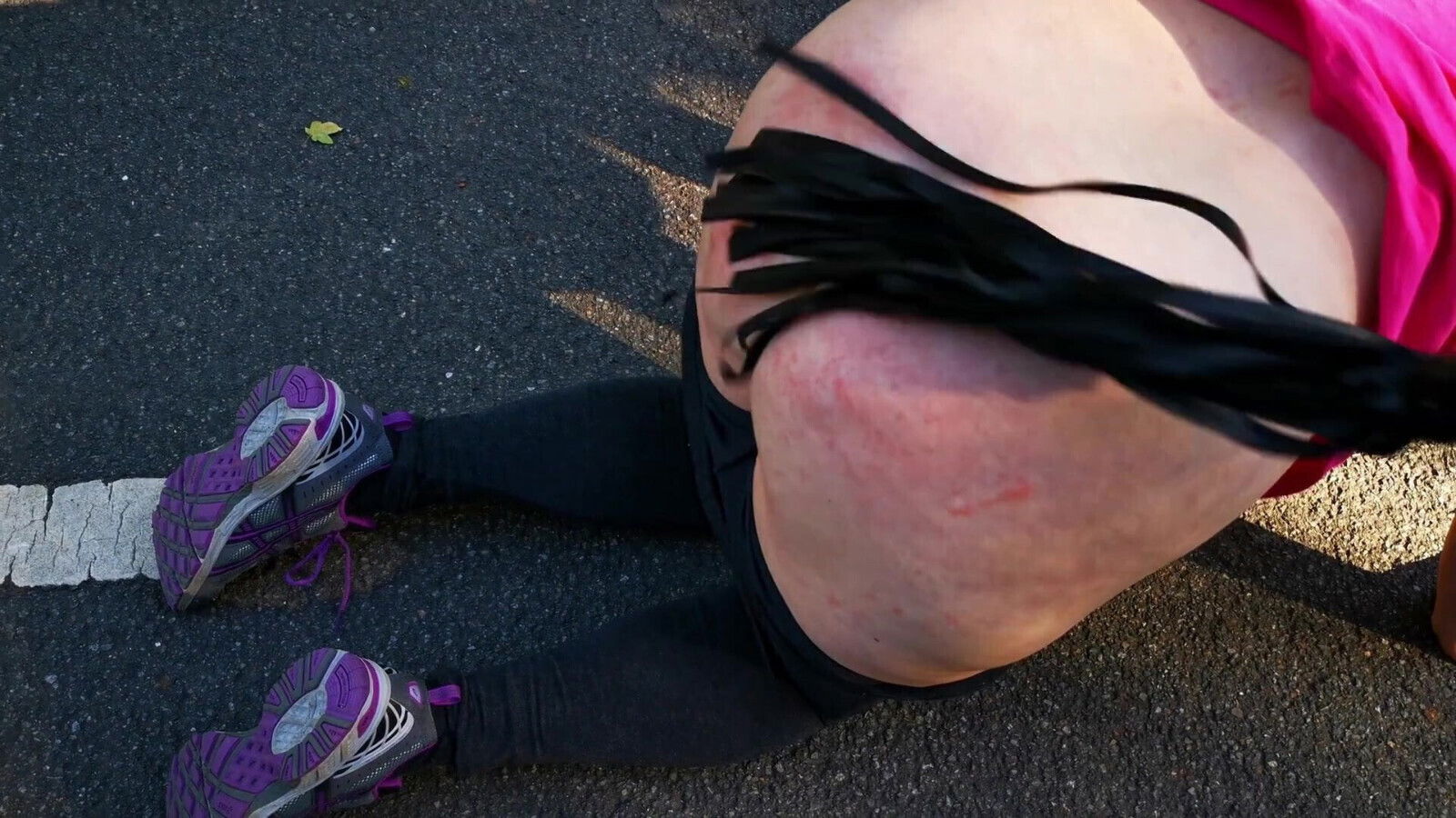 Kneeling middle street whipping bare