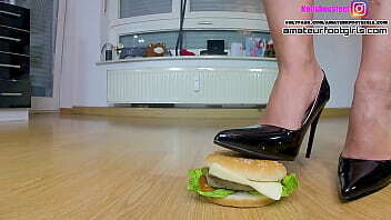 Here Kati crushes hamburgers, walks slowly around hamburgers crushing hamburger fruit, green apple, bananas,grapes with heels, ballerinas barefoot