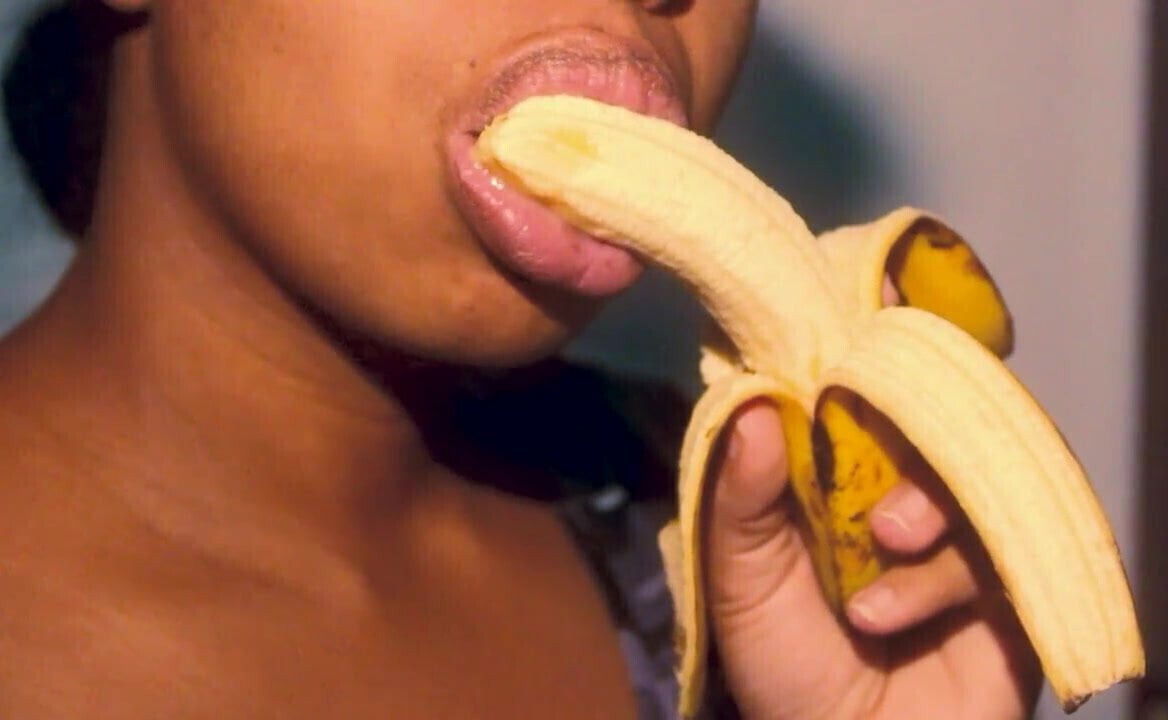 Naughty ebony with sexy lips playing with banana