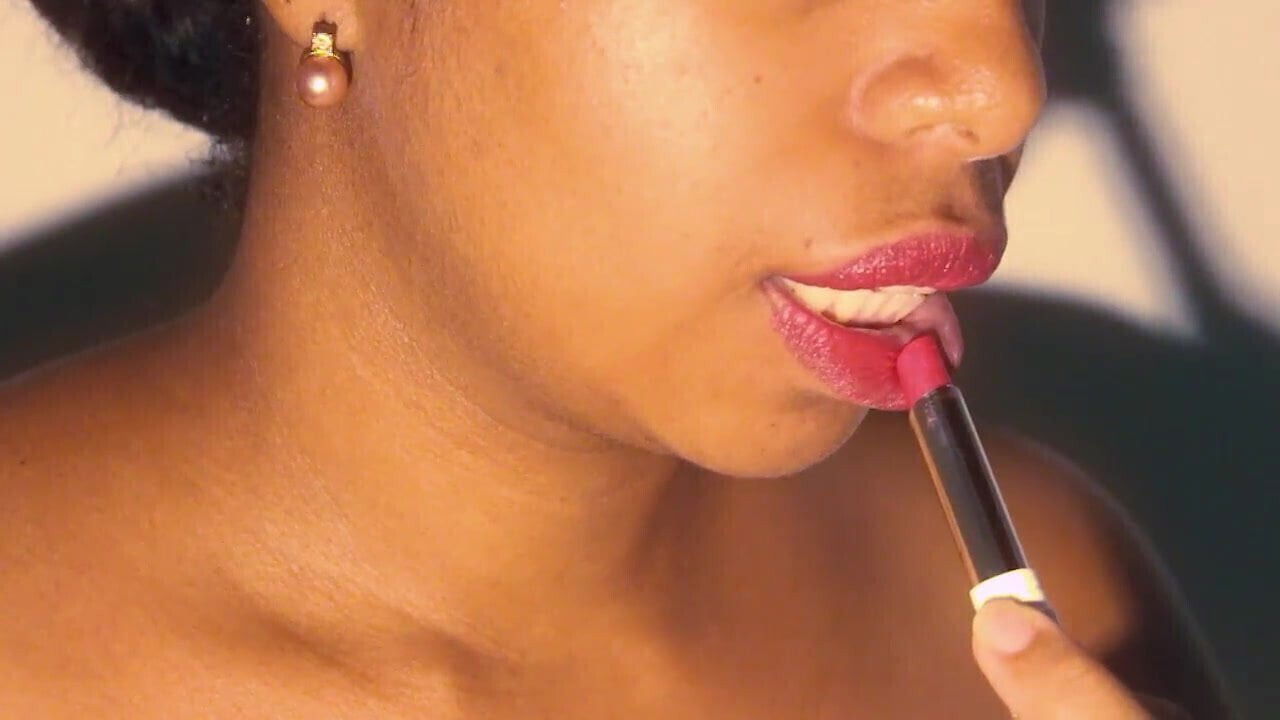 Sexy lips ebony playing with lipstick close
