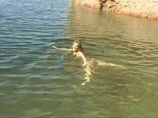 Cute young brunette strips water goes skinny dipping