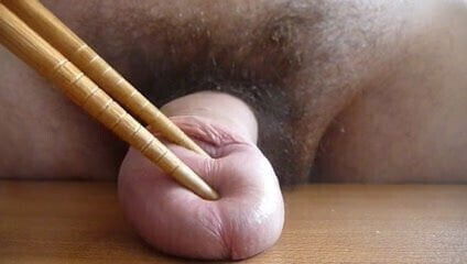 Playing with cock using chopsticks