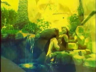 Eccentric chick in weird lighting poses by the waterfall