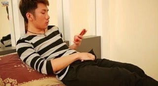 Asian gay strokes his cock in bed