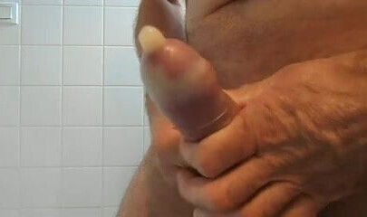 Handjob and big cumshot in a condom .
