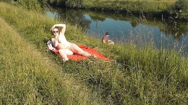 Riverside naked milf sunbathing about random fisher. Outdoors. Wild beach. Public nudity