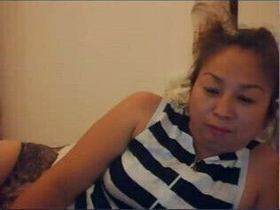 Chinese milf plays with pussy in bed