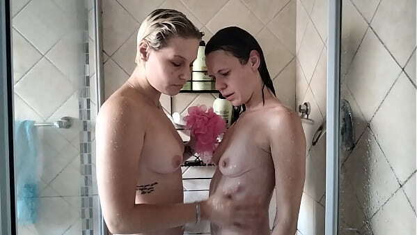 Pale blonde brunette washing each other with loofah shower close soapy body wash