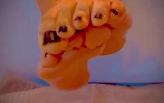 Rubbing sweaty oily feet with painted nails
