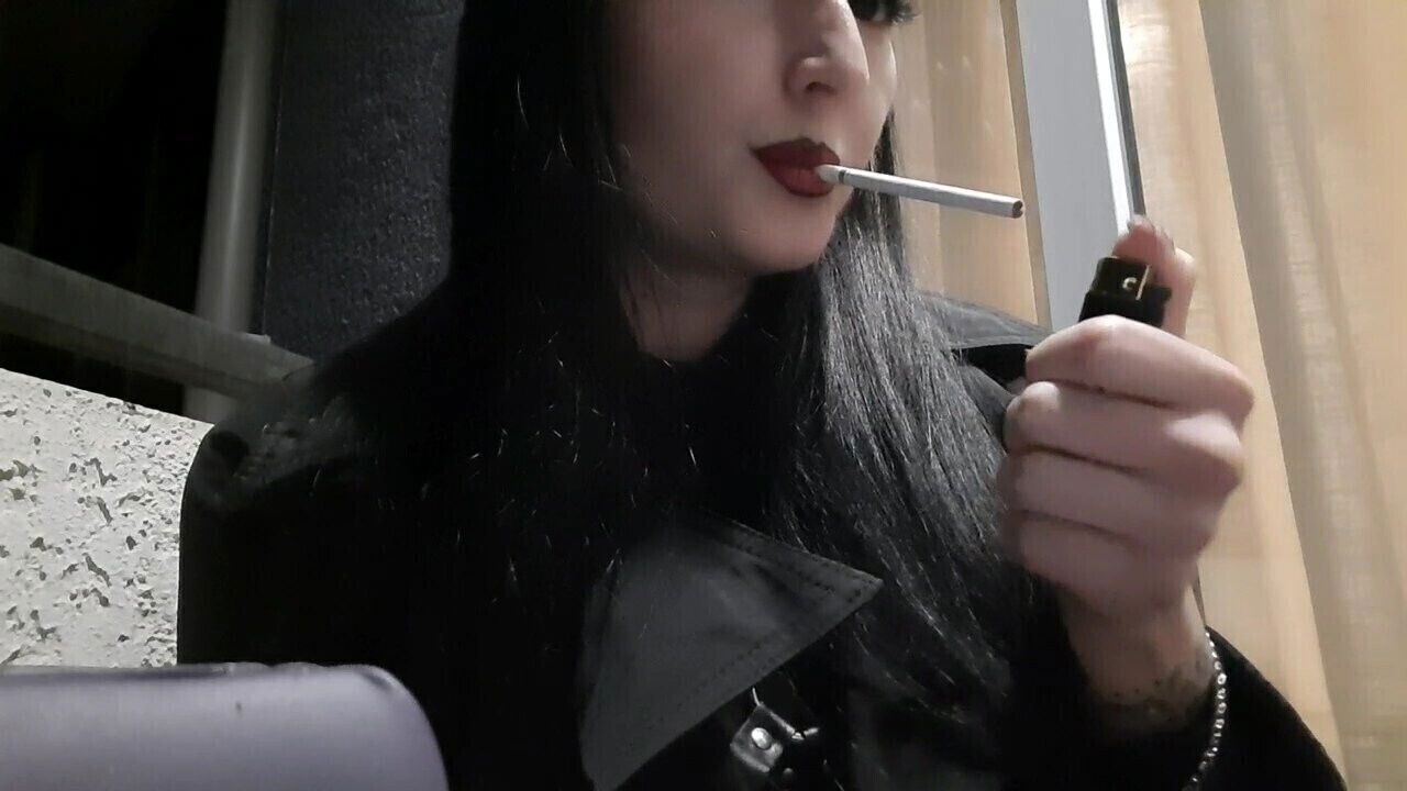 Dominatrix Nika smokes cigarette balcony. Mistress sexy lips blow smoke your face