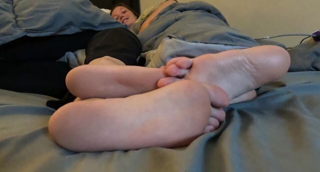 Two girls show their feet while talking