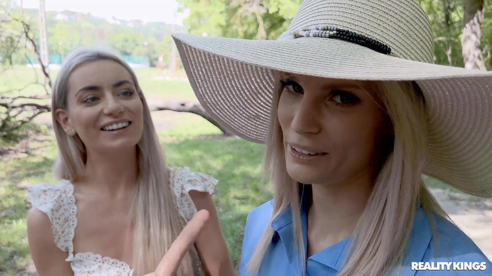 Candee Licious sharing long dildo with Emilly Bellex outdoors