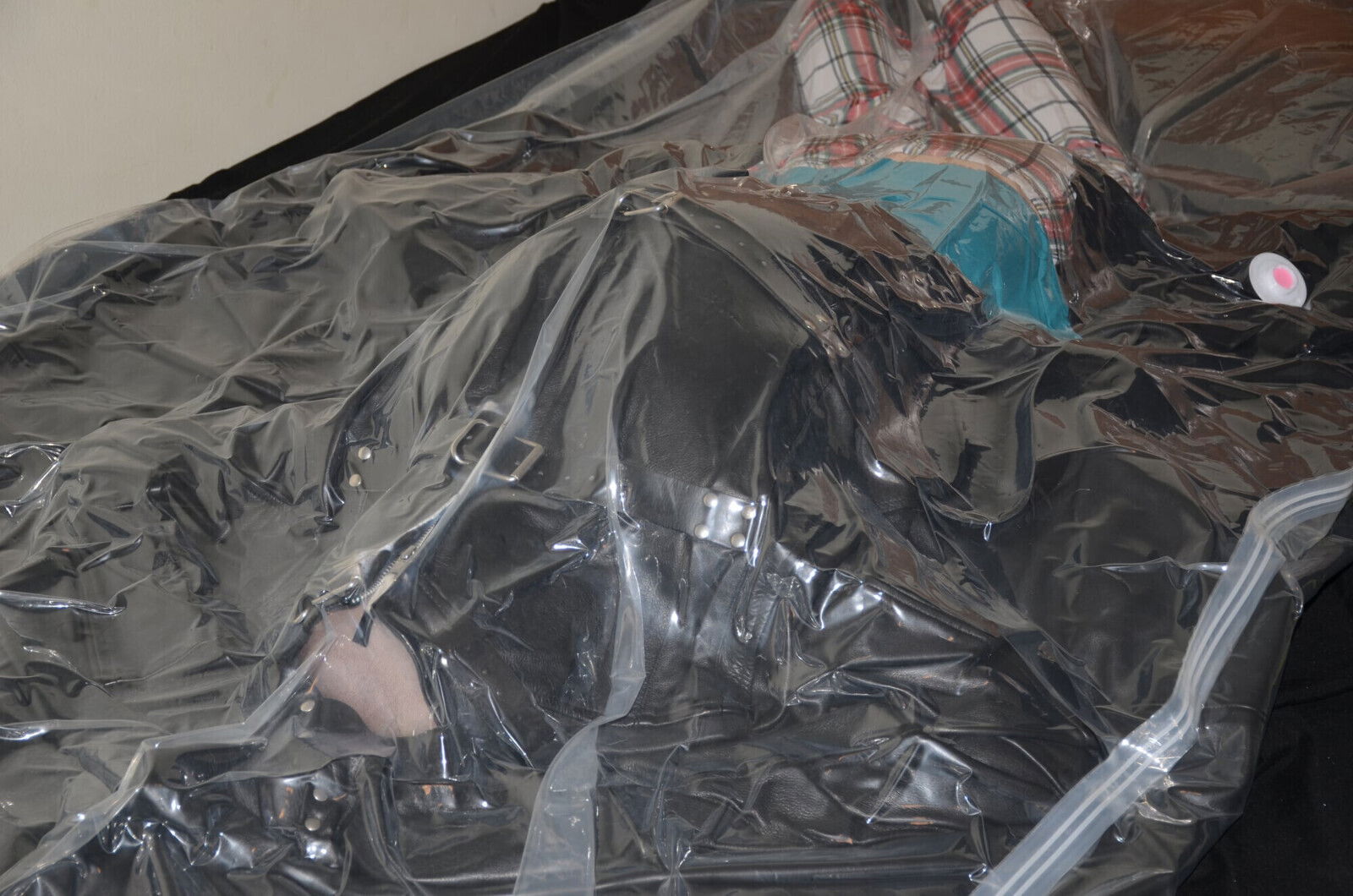 VacPacked under heavy leather sheeting inside leather straitjacket
