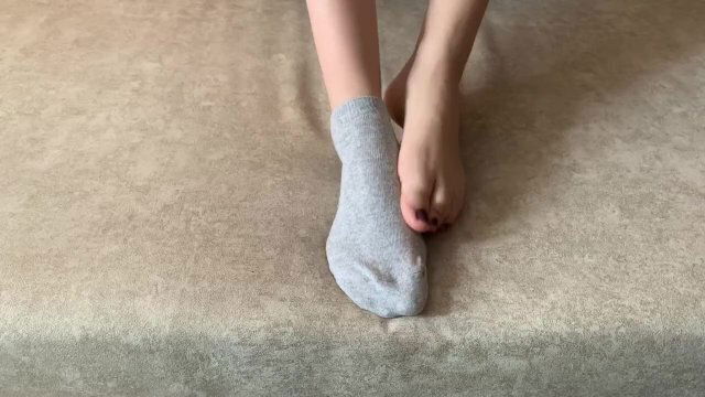 girl caresses legs takes socks with feet