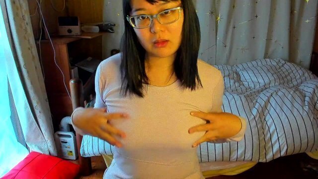 busty Japanese woman feels good caressing nipples through innerwear.