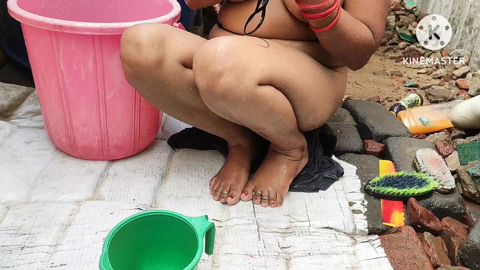 Indian house wife bathing outside with