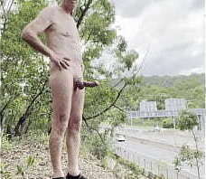 Rob Venuta poses by a busy road in the middle of the afternoon completely visible to drivers